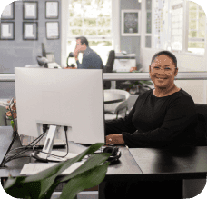A happy lady sitting at her desk.