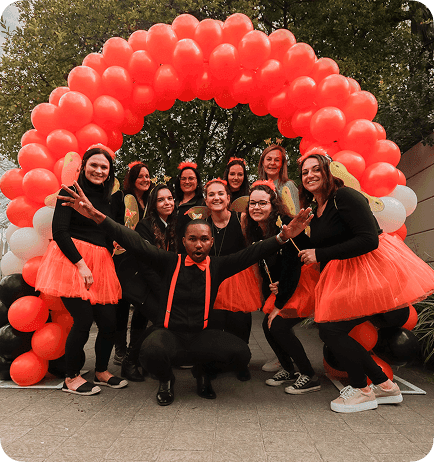 Dotsure employees under an arch of balloons