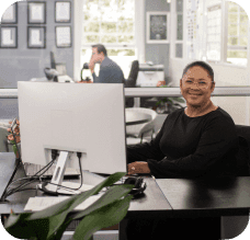 A happy lady sitting at her desk.