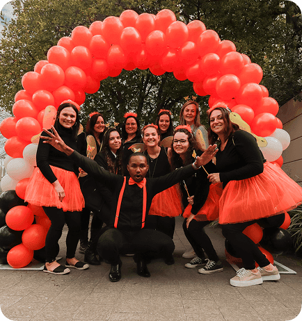 Dotsure employees under an arch of balloons
